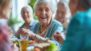 Three older adults sharing conversation and laughter around a community room table