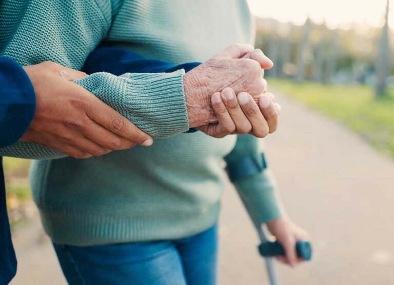 Caregiver reviews a personalized care plan with an older resident at a table.